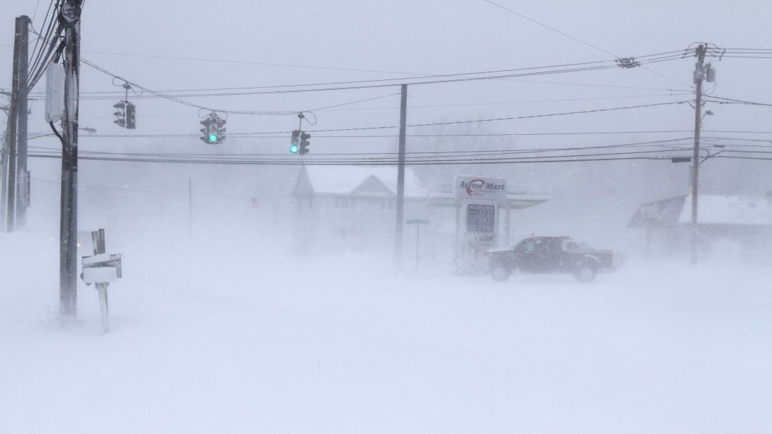 A vehicle drives through a barely visible intersection in Stafford, New York, on January 7.