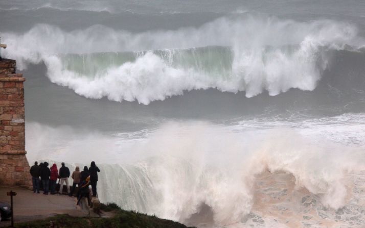 Last year surfing hot spot Praia do Norte in Nazare, Portugal was also graced by mighty waves but this crowd sensibly decided to stay on the shore as the surf broke.