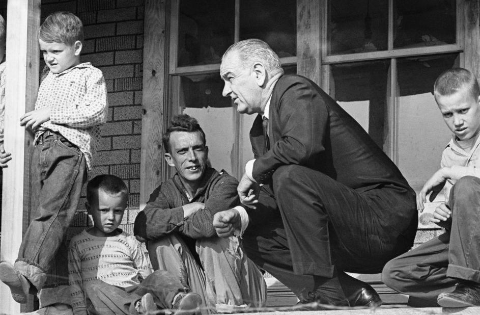 U.S. President Lyndon B. Johnson visits a family in Inez, Kentucky, during a tour of poverty-stricken areas of the country in April 1964. Earlier that year, Johnson declared a "war on poverty" in his State of the Union address. He then worked with Congress to pass more than 200 pieces of legislation, which included early education programs and social safety nets such as Medicare and Medicaid.