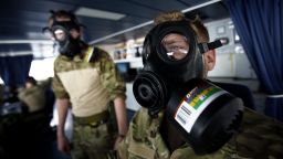 Member of Danish military personnel wearing a protective masks carry out emergency drills aboard the Danish frigate, on the sea between Cyprus and Syria, Friday, Jan. 3, 2014.