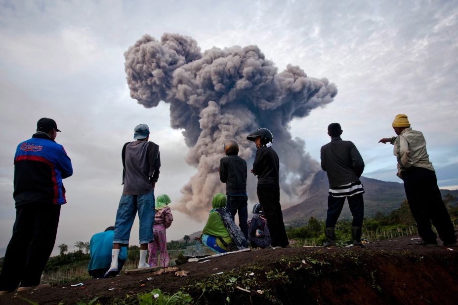 People watch as Mount Sinabung smokes.