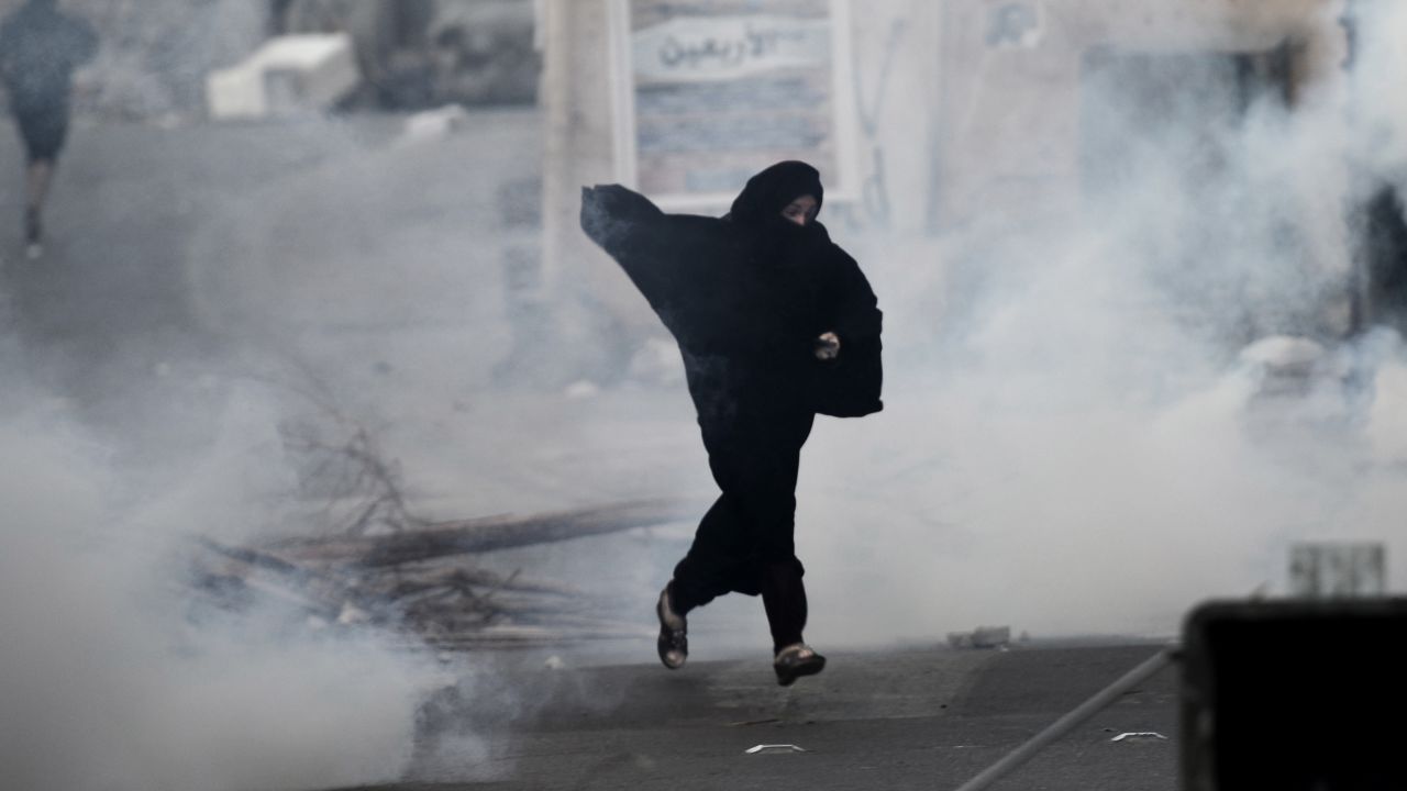 A protester runs from tear gas fired by Bahrain's riot police during a protest west of Manama on December 17.