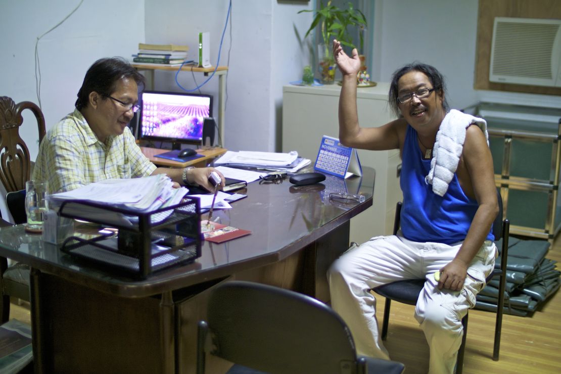 Leo Ladaquin waves a greeting from the mayor's office in Concepcion. On the left is Mayor Villanueva.