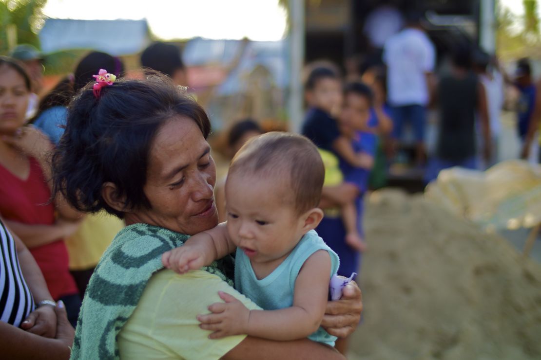 Rowena Costorio and her son Crisantos wait in line for relief supplies.