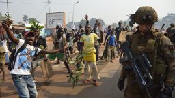 Anti Seleka demonstrators gesture on January 10, 2014 in Bangui as a French soldier part of the Sangaris operation holds position, a few hours before Central African Republic President Michel Djotodia stepped down under regional pressure