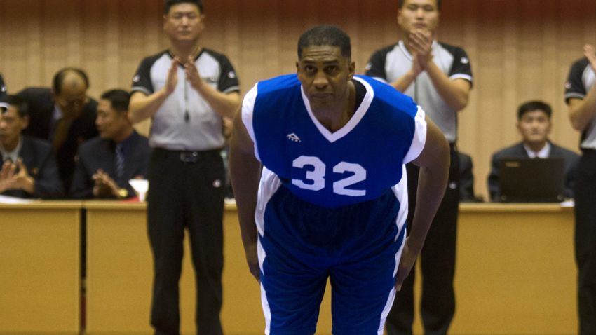 Former NBA star Charles D. Smith bows to North Korean leader Kim Jong Un, seated above in the stands, before an exhibition basketball game with U.S. and North Korean players at an indoor stadium in Pyongyang, North Korea on Wednesday, Jan. 8, 2014. (AP Photo/Kim Kwang Hyon)