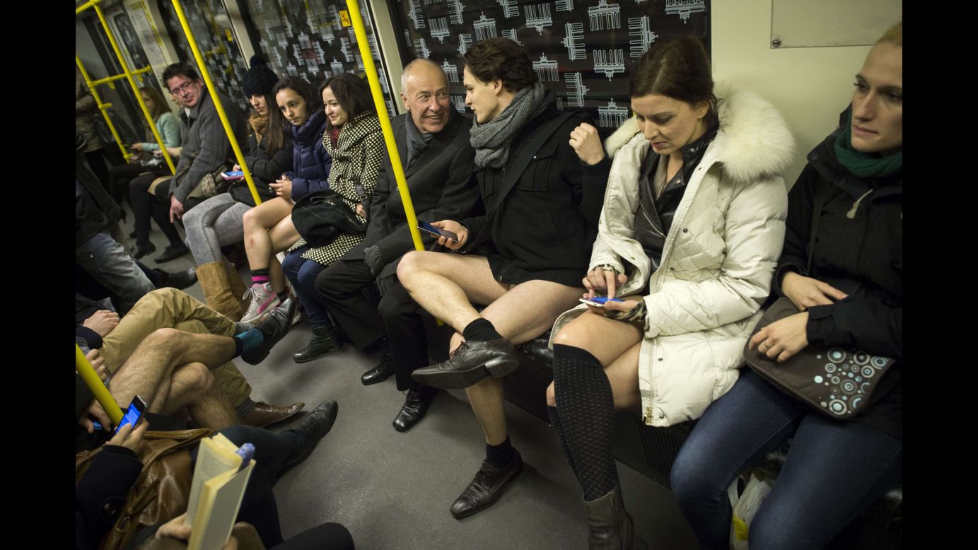 A man in his underwear shares a laugh with a fully clothed man on a train in Berlin.