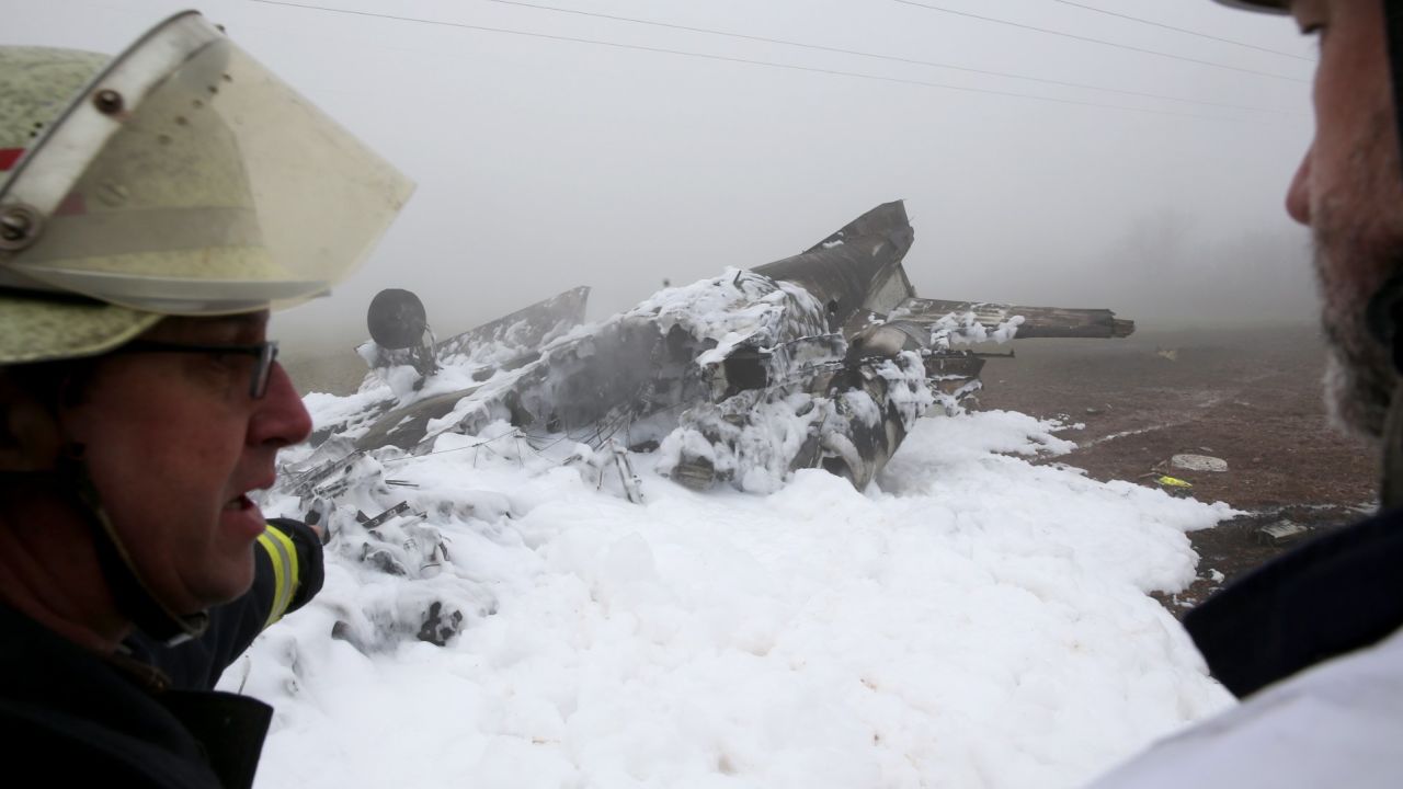 Fire workers stand in front of a burnt-out wreckage of a twin-engine business jet near Rivenich, Germany, on January 12.