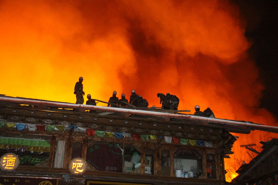 Firefighters work to put out a fire in Dukezong, Shangri-La county, Yunnan province in southwest China on Saturday.