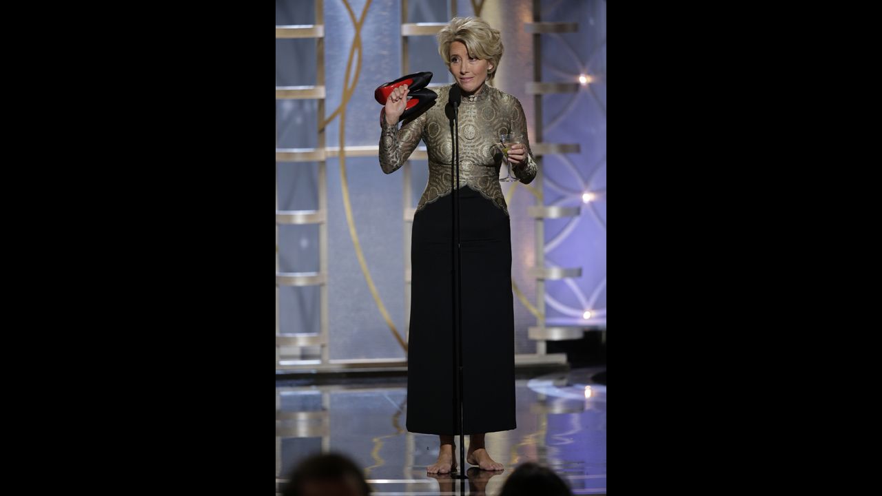 Actress Emma Thompson holds a martini in one hand and her shoes in the other while presenting an award.