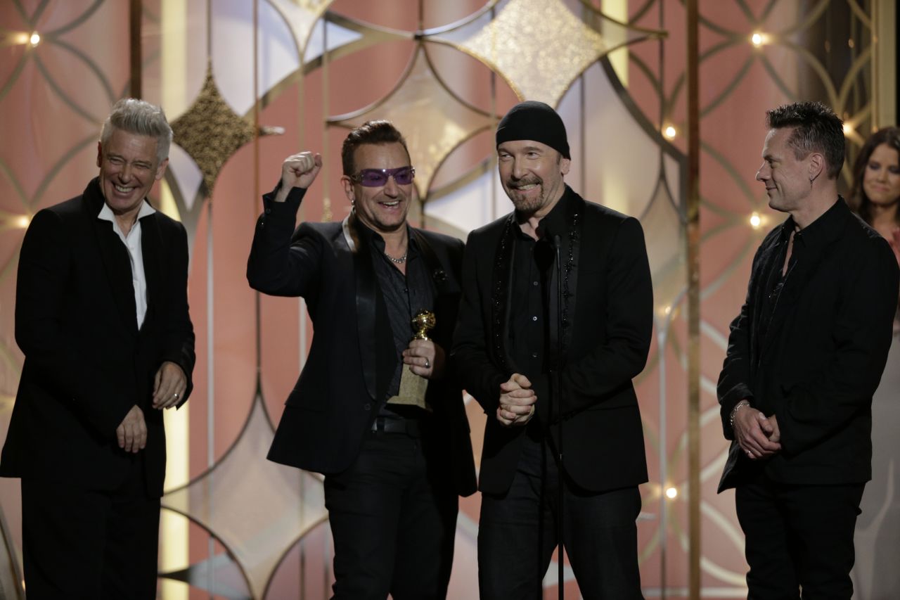Adam Clayton, Bono, The Edge and Larry Mullen Jr. of U2 accept the award for best original song. The song "Ordinary Love" was produced by Danger Mouse and is from the film "Mandela: Long Walk to Freedom."