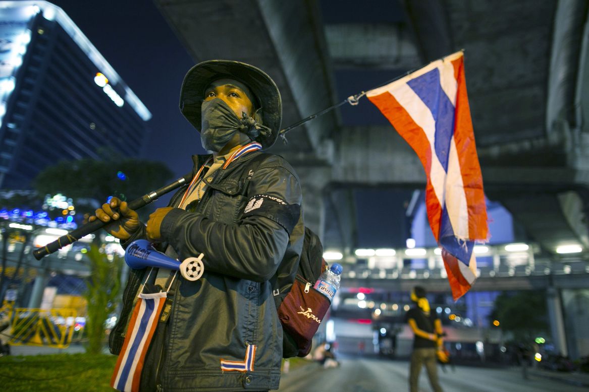 A volunteer security guard stands at one of the anti-government People's Democratic Reform Committee (PDRC) intersections that was shut down in early evening, blocking a major shopping district on January 12, 2014.