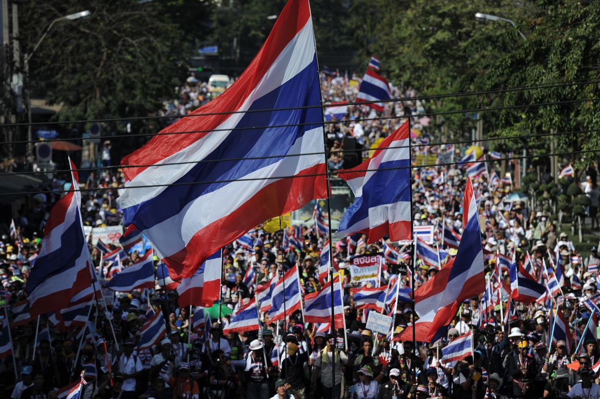 Thai anti-government protesters wave national flags as they march through the streets of Bangkok in a move to "shut down" the city on January 13, 2014.