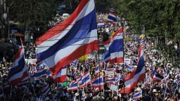 Thai anti-government protesters wave national flags as they march through the streets of Bangkok in a move to 'shut down' the city on January 13, 2014.