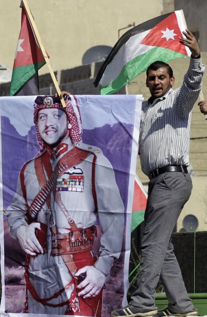 A pro-government protestor holds a banner picturing King Abdullah during a demonstration after Friday prayers in Amman on March 23, 2012.