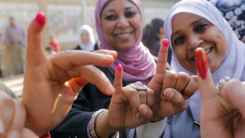 Egyptians women show their inked fingers after casting their votes at a polling station in Cairo, Egypt, Tuesday, Jan. 14, 2014.