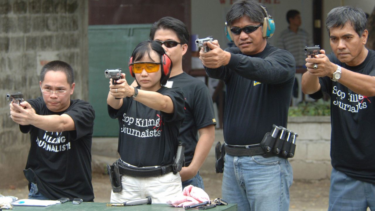 Journalists learn to shoot pistols in Manila in 2005 as part of an advocacy group's campaign to curb attacks against  the media in the Philippines by arming reporters.