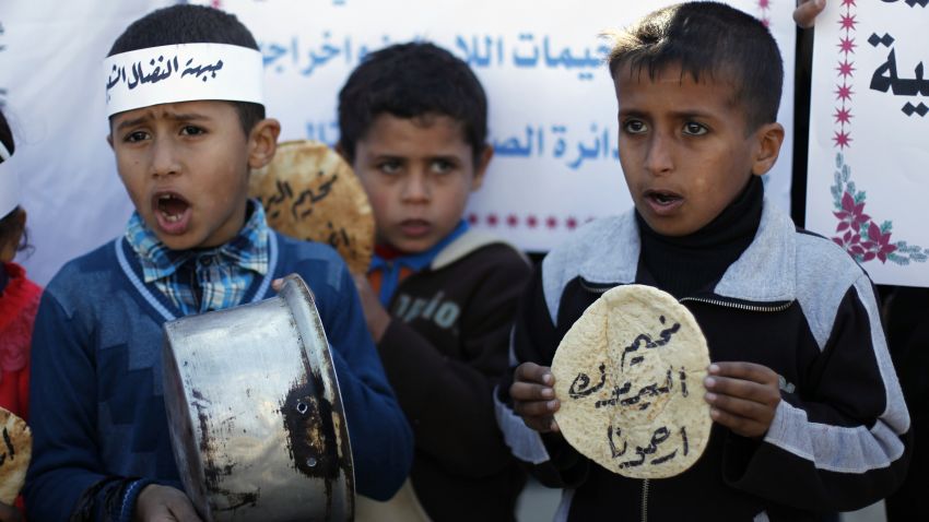 Palestinians children holds bread and pots on January 8, 2014, as they take part in a protest against the poor living conditions at the Yarmuk refugee camp in the Syrian capital Damascus, on January 8, 2014, in Rafah town in the southern Gaza Strip.