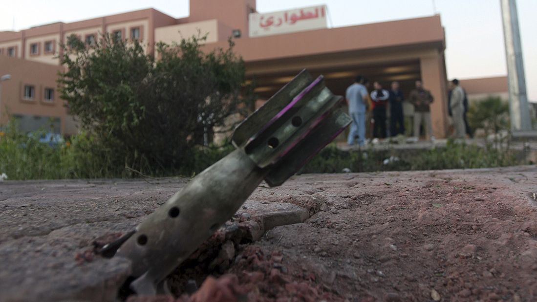 People gather near an unexploded mortar shell in front of a hospital in Falluja on Monday, January 13.