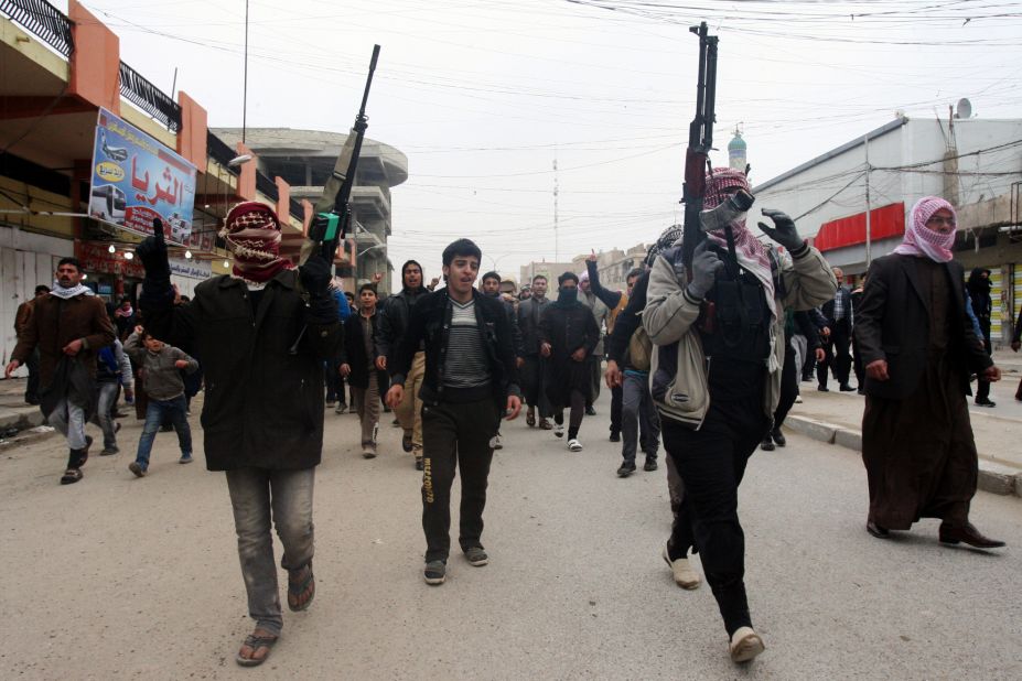 Mourners and Sunni gunmen chant slogans on Saturday, January 4, during the funeral of a man killed during clashes the day before.