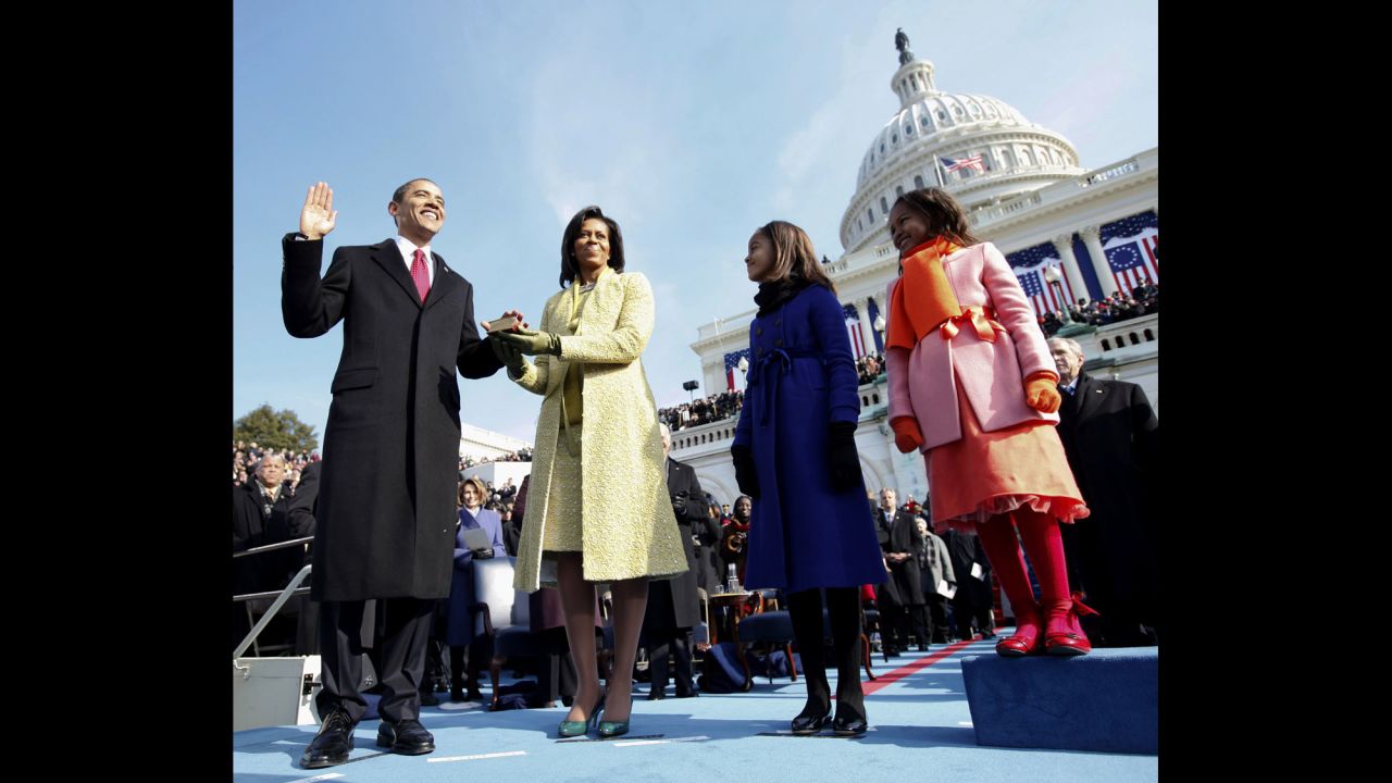 During his inauguration ceremony in Washington, Barack Obama takes the oath of office as his wife holds the Lincoln Bible.
