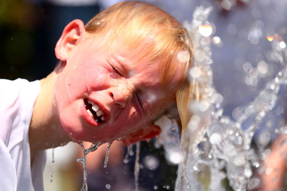  A child plays in the water fountain in the heat during day four of the 2014 Australian Open in Melbourne.