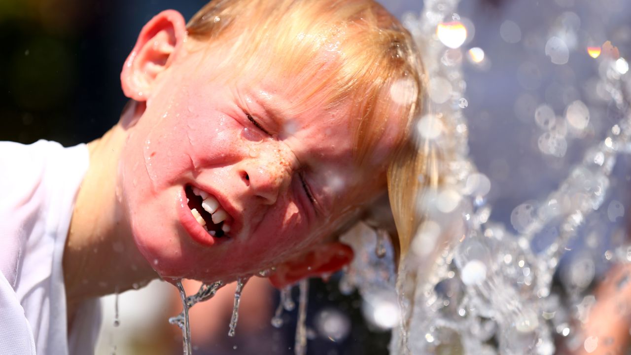 A child plays in the water fountain in the heat during day four of the 2014 Australian Open in Melbourne.
