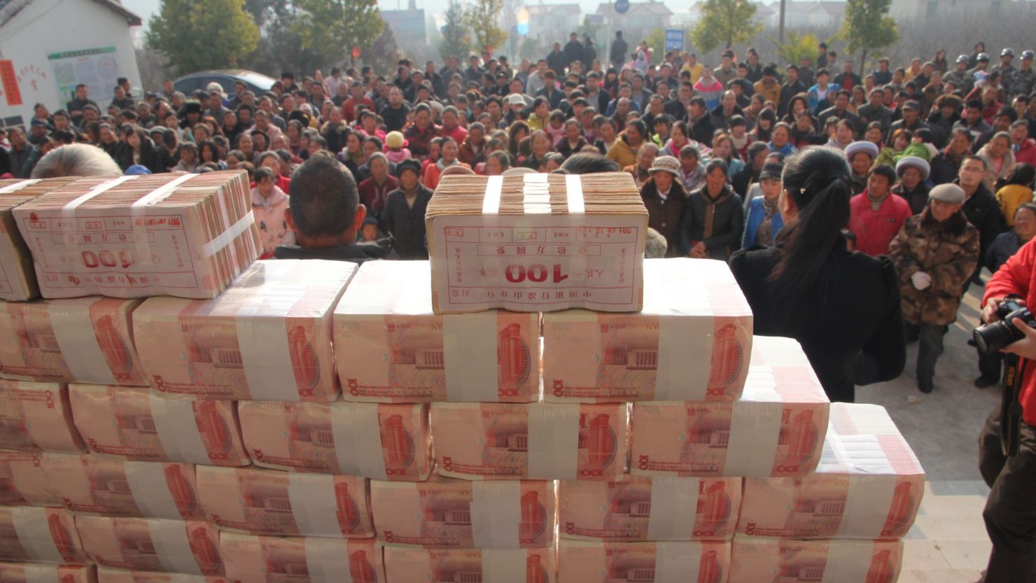 Villagers stand in front of a 'money wall' in Sichuan, China waiting to collect their year-end bonus from their investments on 14 January.