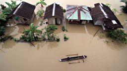 Residents ride a wooden boat as they paddle past submerged houses due to flooding brought about by heavy rains in the outskirts of Butuan City, Agusan del norte province, in southern island of Mindanao on January 13, 2014.