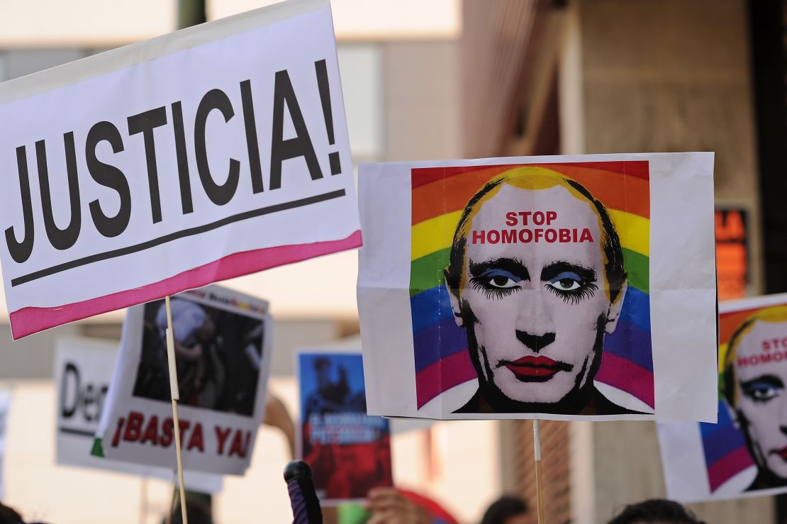 A protester holds up an image of Putin wearing lipstick in Madrid in 2013.