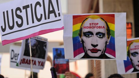 A protester holds up an image of Putin wearing lipstick in Madrid in 2013.