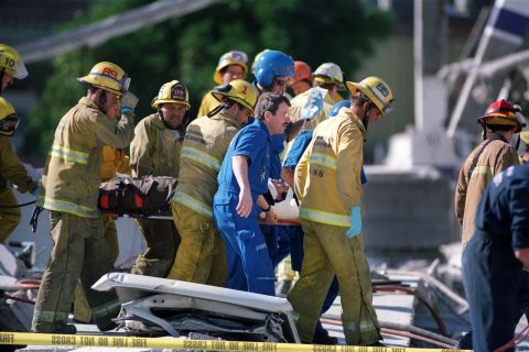 Firefighters carry a janitorial worker who was rescued from a collapsed garage at the Northridge Mall in Northridge, California. The earthquake occurred in the early morning, at 4:31 Pacific Standard Time.