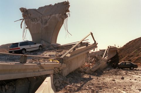 A few hours after the earthquake, cars sit in the rubble of a collapsed highway ramp in Sylmar, California.