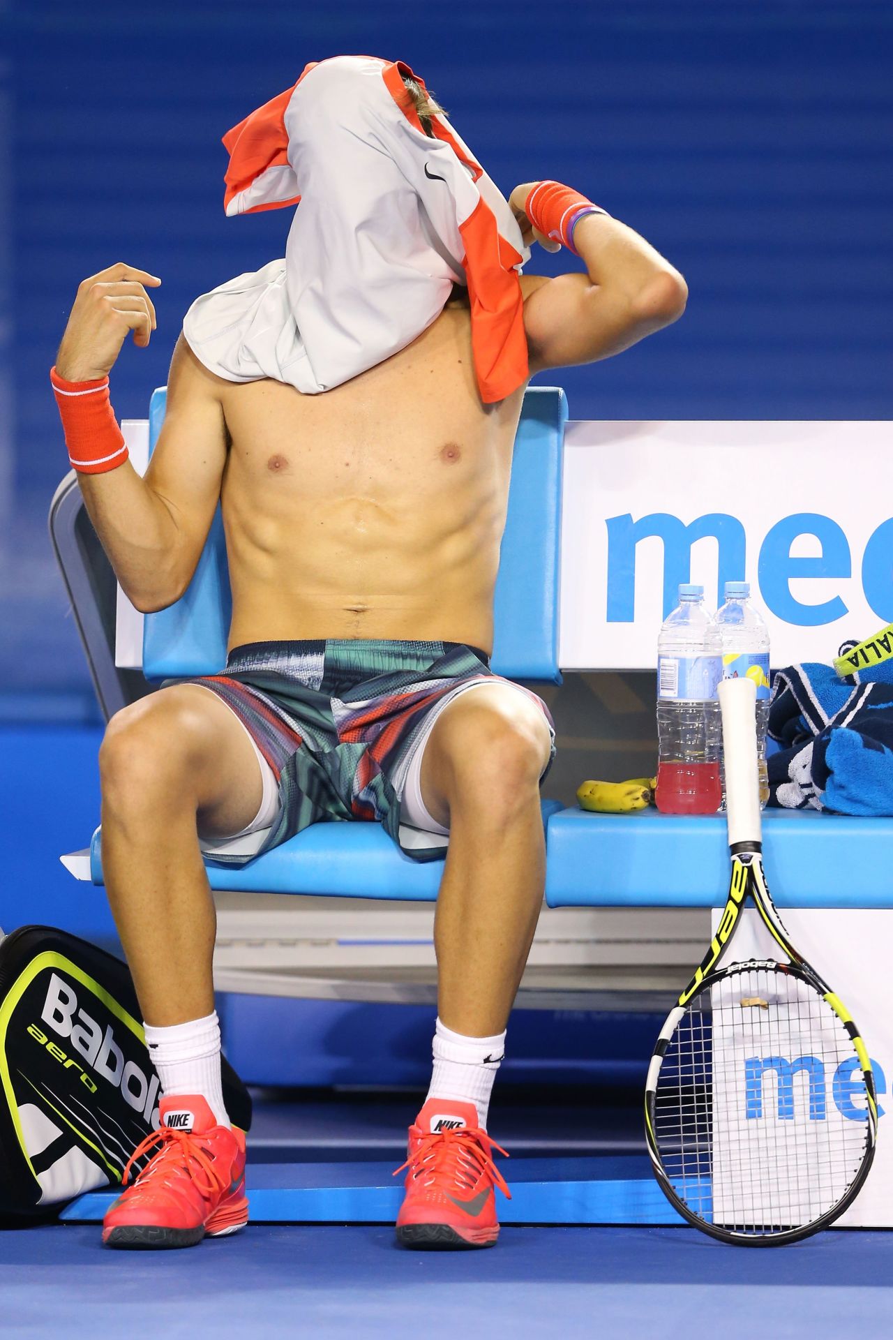 Thanasi Kokkinakis de Australia se cambia de camiseta en su partido contra Rafael Nadal.