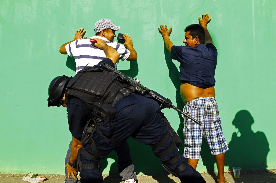 Mexican federal police check men in the streets of Apatzingan on Wednesday, January 15. Some vigilante groups have vowed not to hand over their guns until cartel leaders are captured.