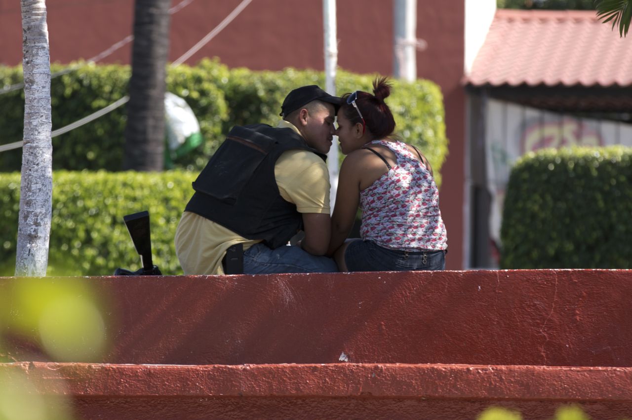 A man belonging to a group called the Self-Defense Council of Michoacan kisses a woman in Nueva Italia's main square on Monday, January 13.