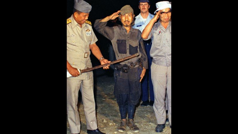 Hiroo Onoda, center, salutes after handing over his military sword on Lubang Island in the Philippines in March 1974. Onoda, a former intelligence officer in the Japanese army, had remained on the island for nearly 30 years, refusing to believe his country had surrendered in World War II. He died at a Tokyo hospital on Thursday, January 16. He was 91. 