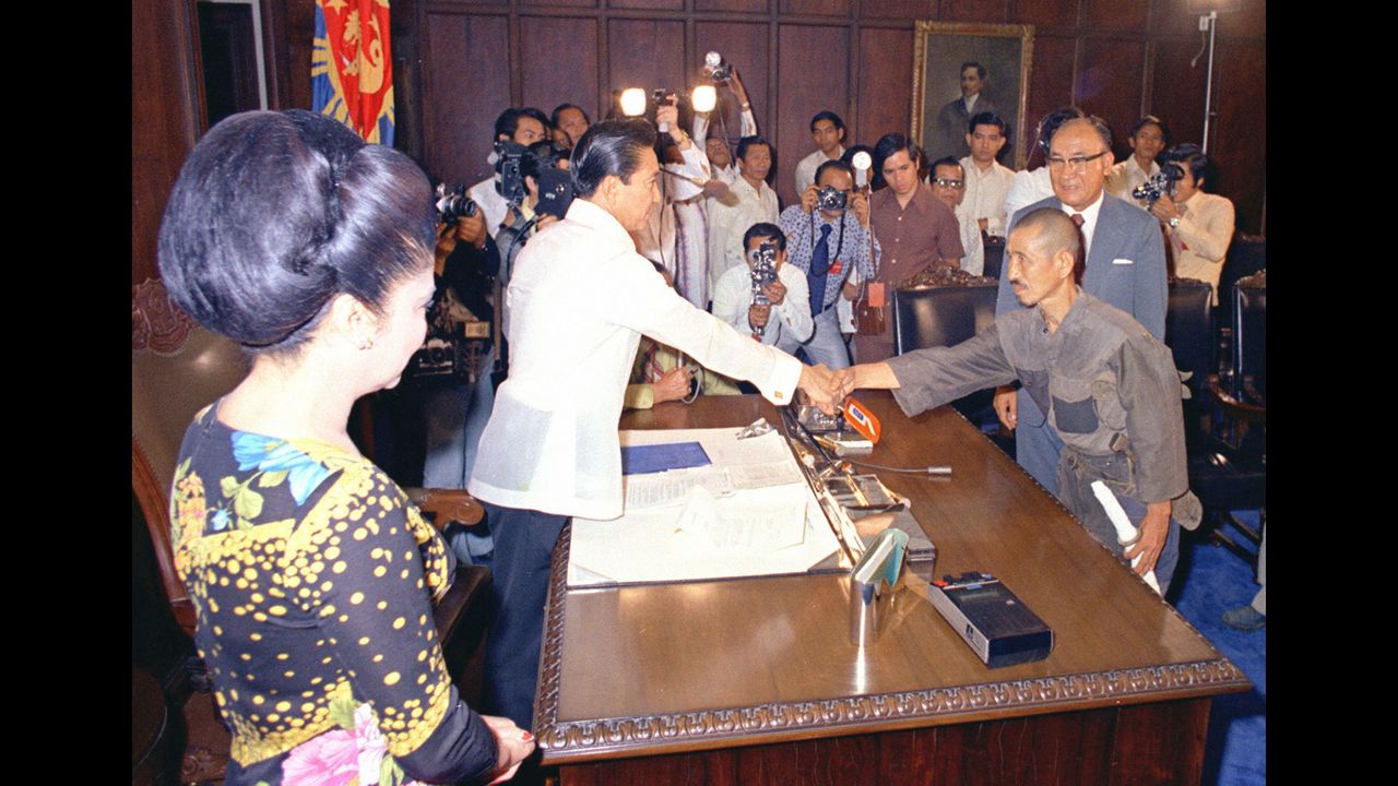 Philippine President Ferdinand Marcos, left, greets Onoda at Malacanang Palace in Manila under the watchful eye of first lady Imelda Marcos in March 1974. Nearly three decades after World War II's end, Onoda was persuaded to come out of hiding after his former commanding officer traveled to Lubang and told him he was released from his military duties.