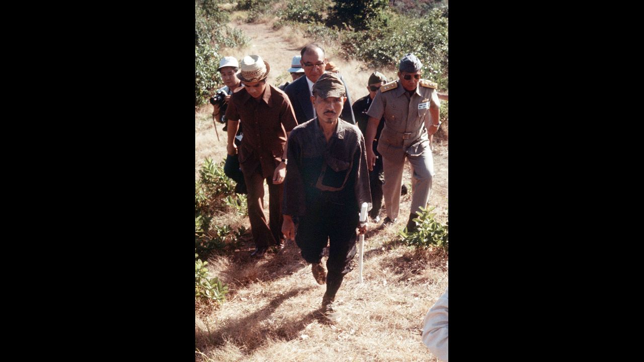 In March 1974, Onoda, center, walks from the jungle where he had survived since World War II on Lubang Island. 