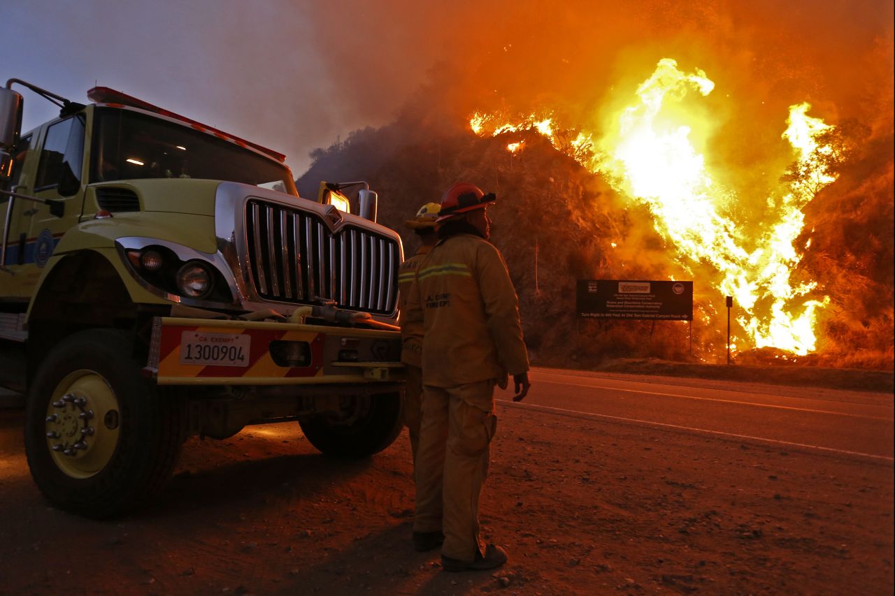 Firefighters watch the Colby Fire on January 17. The blaze began before dawn Thursday, January 16, and allegedly originated with three men camping in the foothills near Glendora, California, authorities said.