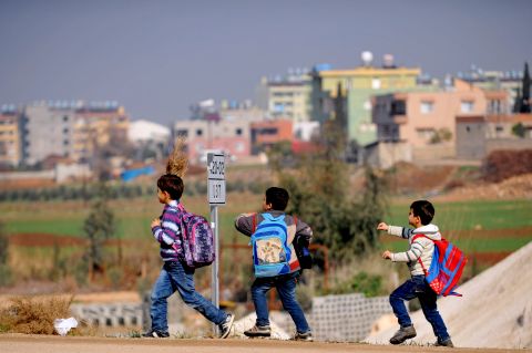 Syrian children walk on the street after attending school January 18 in Hatay.