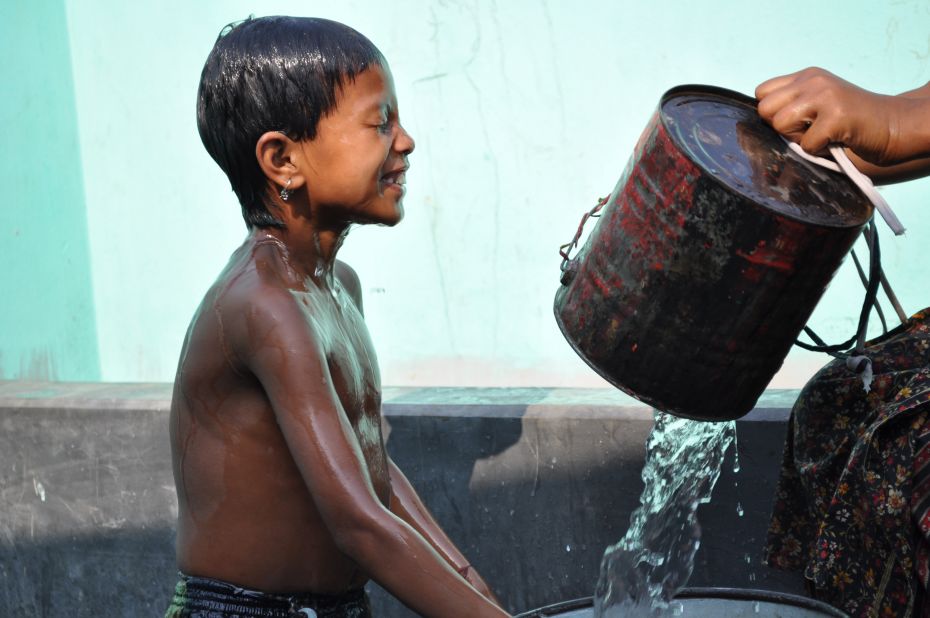 A young boy takes a bath at a public water stand post near Uttar Bishli, Bangladesh.