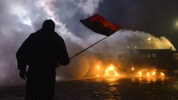 A protester waves a flag during the clash with police in the centre of the Ukrainian capital Kiev on January 20, 2014, after 200,000 turned up for an opposition rally in a show of defiance against strict new curbs on protests