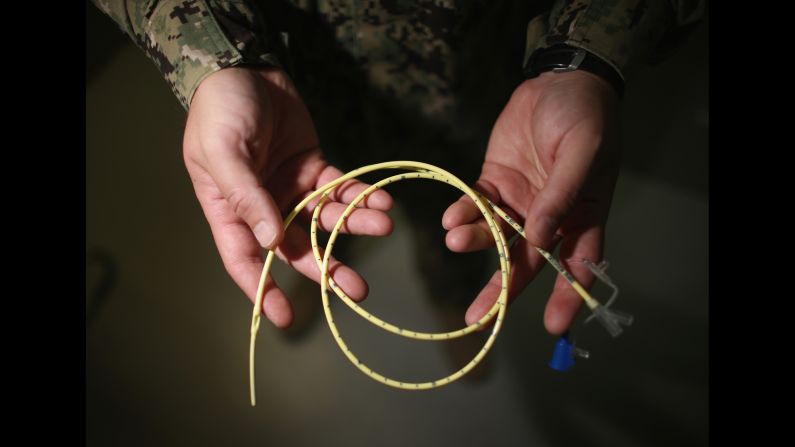 A military doctor holds a feeding tube used to feed detainees on a hunger strike in June 2013. In March 2013, the US military announced that dozens of detainees had begun a hunger strike. By that June, <a href="index.php?page=&url=http%3A%2F%2Fwww.cnn.com%2F2013%2F06%2F18%2Fhealth%2Fguantanamo-hunger-strike%2F">more than 100 detainees were on a hunger strike,</a> and more than 40 were being force-fed, military officials said.