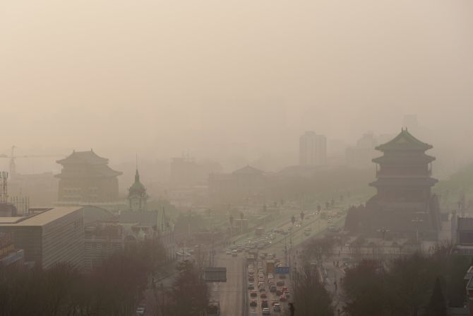 Los vehículos se desplazan lentamente por un camino de smog pesado en Beijing, China, el 16 de enero de 2014.