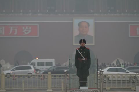 A police officer stands guard in Beijing's Tiananmen Square on January 16. The co-author of a new study recommends increasing the efficiency of manufacturing processes and re-examining energy production to decrease pollution in China.