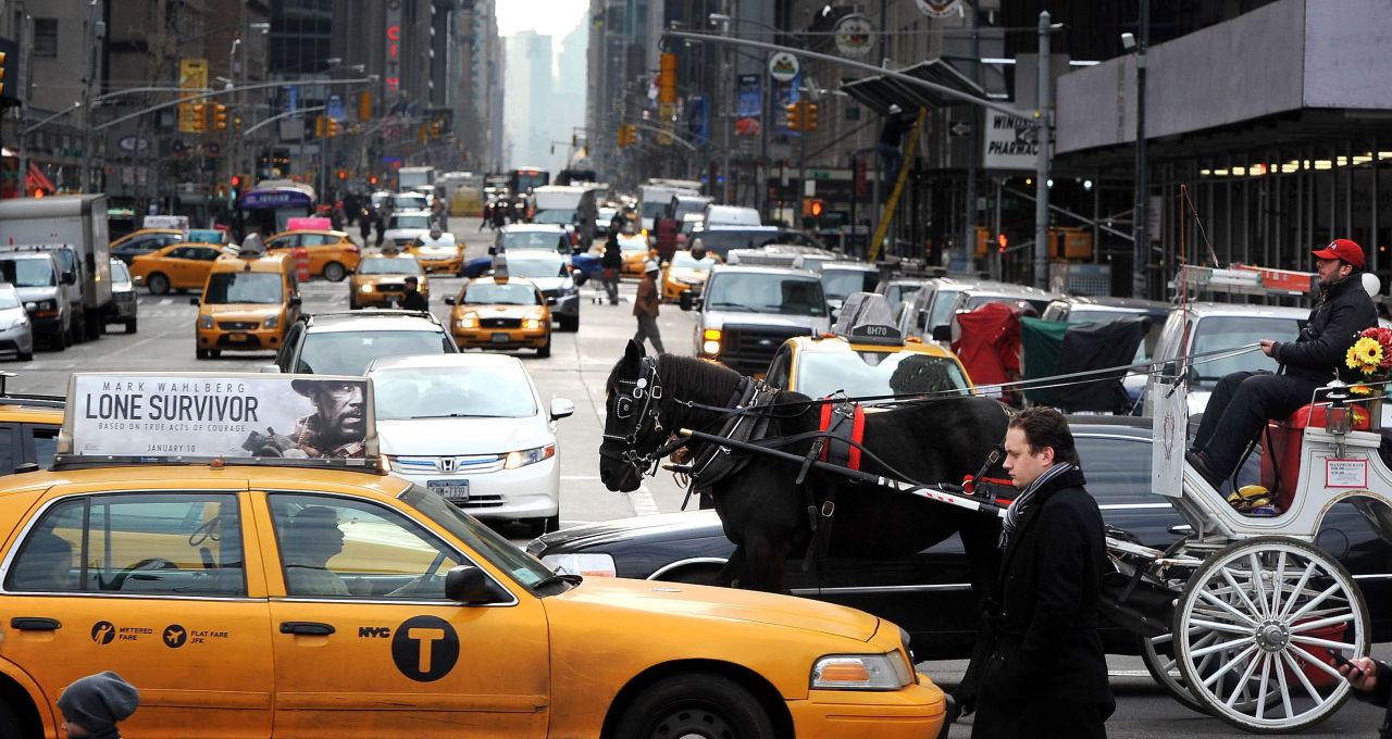 A horse pulls a carriage between cars and cabs along 59th Street in January 2014. 