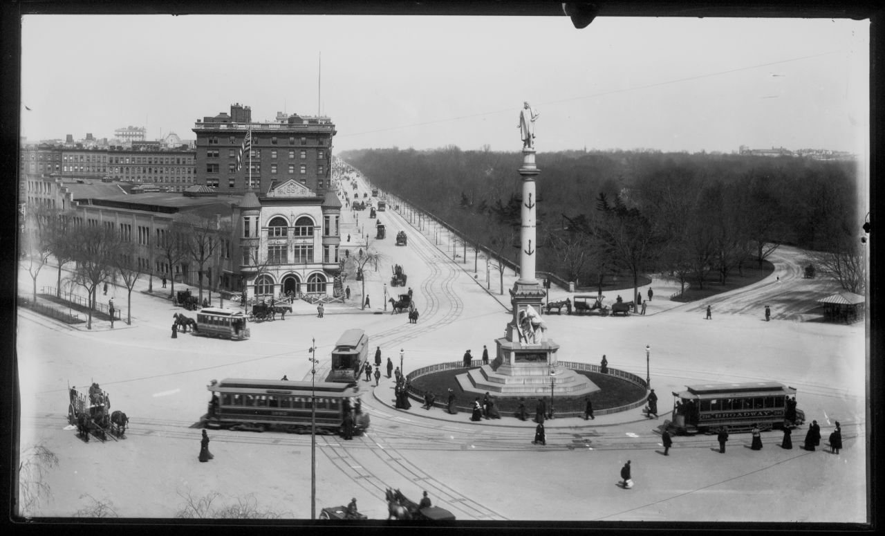 Trolley cars, pedestrians and horse-drawn carriages negotiate the traffic around Columbus Circle at the southwest corner of Central Park in the late 1900s. 