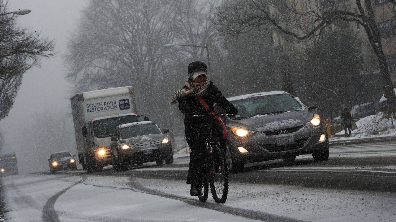 Commuters make their way under a snowfall on January 21, 2014 in Washington, DC. 