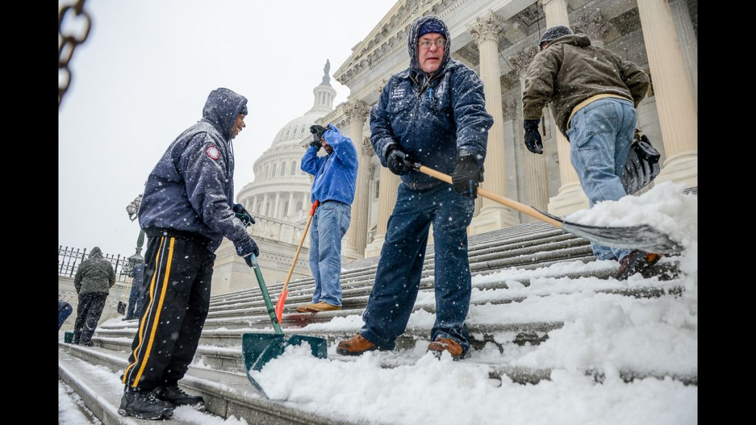 Workers clear snow off the steps of the U.S. Capitol in Washington on January 21.